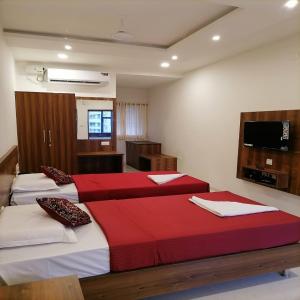 a bedroom with two beds with red and white sheets at FOUR SQUARE COMFORTS in Manipal