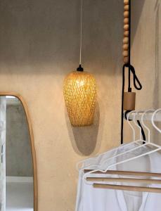 a yellow pendant light hanging from a wall at Synoikies by Oikieskiathos in Skiathos