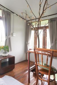 a room with a chair and a table and window at Suksamer Relaxation Homestay 