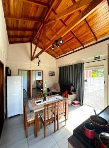 a kitchen and living room with a wooden ceiling at CASA CLIMATIZADA COM HIDROMASSAGEM PRÓXIMO BETO CARRERO E PRAIAS - Casa 2 DuMar Hospedagem in Penha