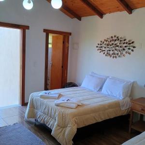 um quarto com uma cama grande e toalhas em Chalé Torneados em Tiradentes