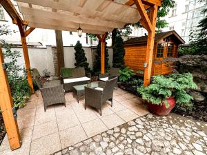 a patio with a table and chairs and a wooden pergola at Alfons Boutique Hotel in Prague