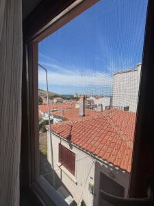 Blick aus einem Fenster auf ein Dach in der Unterkunft Bozcaada Vitis Hotel in Bozcaada