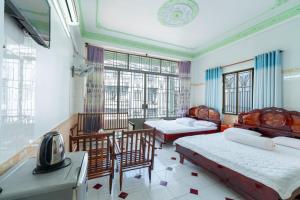 Thien Thanh Hotel في فينه لونج: غرفة نوم بسريرين وطاولة وكراسي