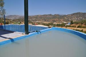a swimming pool with a view of the mountains at Ferme Dar Aicha green Bellouta in Bellouta