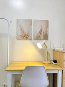Cabaguio的住宿－Stylish Studio in Downtown with Remote Work Setup，一张带台灯和白色椅子的桌子