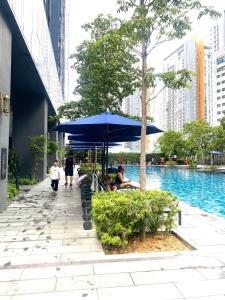 a group of people sitting under an umbrella next to a pool at Eastern Suites Star KLcc in Kuala Lumpur