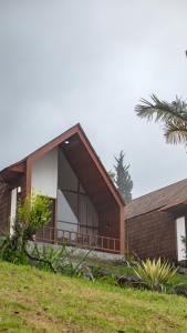 a house on a hill with a palm tree at Catu Glamping Bedugul in Tabanan