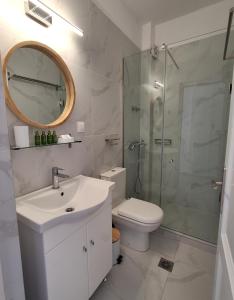 a bathroom with a toilet and a sink and a shower at Villa Thalassa Apartments in Pefkohori
