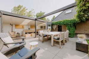 Un patio al aire libre con mesa y sillas. en Bed & Breakfast BBNo9, en Arum
