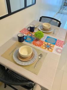 a table with a table cloth with plates and utensils at Stylish Studio in Downtown with Remote Work Setup in Cabaguio