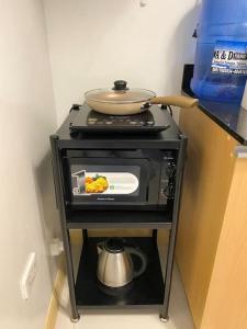 a stove with a pot on top of it at Stylish Studio in Downtown with Remote Work Setup in Cabaguio