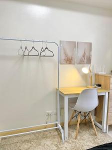 Cabaguio的住宿－Stylish Studio in Downtown with Remote Work Setup，书桌旁的一张带白色椅子的桌子和一张桌子