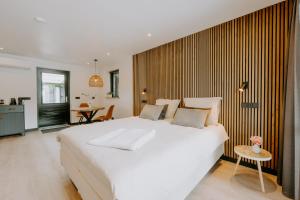 Un dormitorio con una gran cama blanca y una mesa. en Bed & Breakfast BBNo9, en Arum