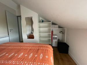 Una habitación abuhardillada con una cama y una escalera en Maison de 2 chambres proche A11 Ancenis, Logis du Château Rouge, en Mésanger