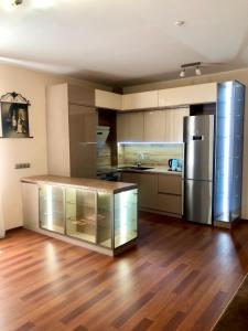 a kitchen with a stainless steel refrigerator and wooden floors at Helen Hotel in Mykolaiv