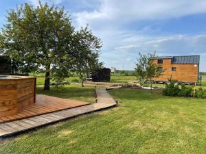 a wooden deck in a field with a building at Tiny House in Sainte-Marie-en-Chaux