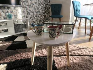 two coffee mugs sitting on a table in a living room at Sibiu Cigalyne in Cristian