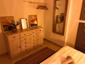 a bedroom with a dresser and a mirror at Teichapartment in Michelbach an der Bilz