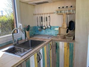 a kitchen with a sink and a counter with utensils at Tiny du Verger de la Pommeraye in Morgny-la-Pommeraye