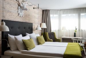Schlafzimmer mit einem großen weißen Bett und einem Schreibtisch in der Unterkunft AMERON Luzern Hotel Flora in Luzern
