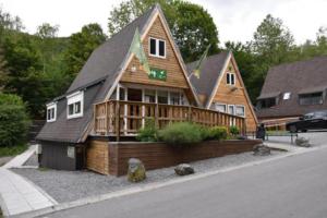 a large wooden house on the side of a street at Het vlindertje in Durbuy