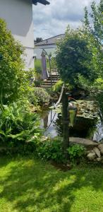 a garden with a pond in a yard with a umbrella at Ferienwohnung Supp in Zweibrücken