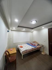 Dormitorio pequeño con cama y mesa en Combretrata en Phnom Penh