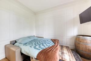 ein Schlafzimmer mit einem Bett und einem Fass in der Unterkunft Coup de cœur parisien à 15 mn de Paris - 45 mn Disney in Noisy-le-Sec