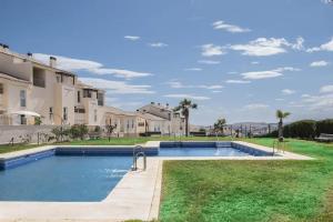 a swimming pool in front of a building at Relaxation, GOLF and Beach in Caleta De Velez