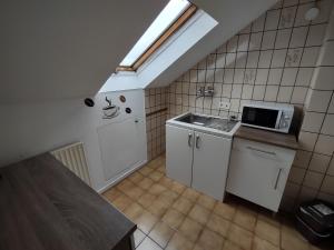 a small kitchen with a sink and a microwave at Monteurzimmer in Vellmar mit Küche und Bad in Vellmar
