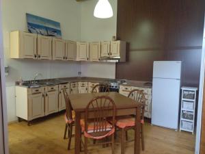 a kitchen with a table and chairs and a refrigerator at Segesta Antichi Sapori in Calatafimi