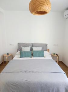 een slaapkamer met een groot bed met blauwe kussens bij Apartamentos La Casa del Maestro in Alhama de Aragón