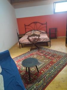 ein Schlafzimmer mit einem Bett und einem Teppich mit einem Tisch in der Unterkunft Segesta Antichi Sapori in Calatafimi