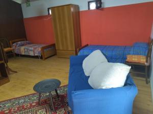 ein Wohnzimmer mit einem blauen Sofa und einem Bett in der Unterkunft Segesta Antichi Sapori in Calatafimi