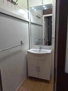 a white bathroom with a sink and a mirror at Segesta Antichi Sapori in Calatafimi