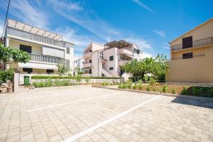 an empty parking lot in front of two buildings at Family Petrov Apartments in Vodice