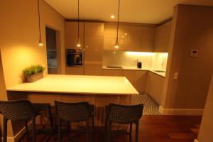 a kitchen with a counter and chairs in it at New Oporto Apartments - São Bento in Porto