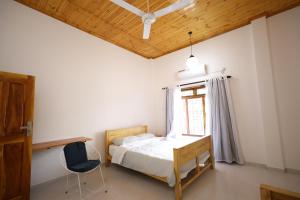 a bedroom with a bed and a chair and a window at Sunflowers Canada House in Jaffna