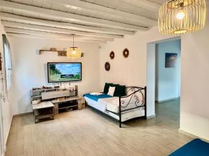 ein Schlafzimmer mit einem Bett und einem TV. in der Unterkunft Vaqueros in Mykonos Stadt