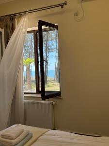 ein Schlafzimmer mit einem Fenster und ein Bett mit Handtüchern in der Unterkunft Oxygen Hotel in Shekhvetili