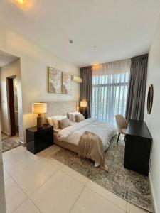 Un dormitorio con una cama y un escritorio y una ventana. en GreenHome 75 inch TV 5mints from the beach and City, en Dar es Salaam