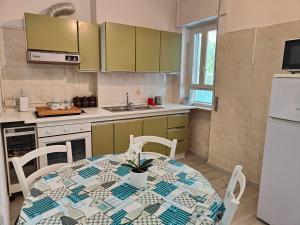 una cucina con tavolo e una cucina con armadi verdi di Appartamentino Luigi (Gaeta Holidays) a Gaeta Altre 24 foto