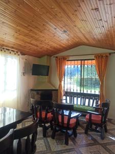 a dining room with a table and chairs and a window at Casa Hotel Descanso Real in Paipa