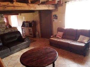 Una sala de estar con dos sofás de cuero y una mesa. en Ancienne dépendance pierre et bois, en Alan 23 fotos más