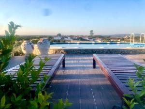 widok na basen z dwoma ławkami obok niego w obiekcie Casa Alfazema do Monte w mieście Santa Marta