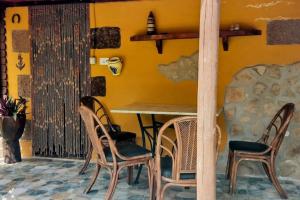een tafel en stoelen in een kamer met een gele muur bij Villa Tamadaba Rural Home - Pet Friendly, Near Ocean, Ideal for Long Stays in Agaete