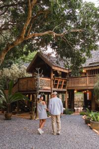 a man and a woman standing in front of a building at Ban MaeBo Local Stay in Ban Nong Han
