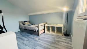 a small bedroom with a bed and a table at Charmante maison au Nord de Paris piscine chauffée in Argenteuil
