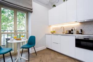 a kitchen with white cabinets and a table and chairs at Old Town Residence at Topolowa in Krakow